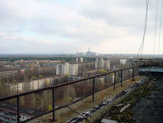 The abandoned city of Pripyat with Chernobyl plant in the distance